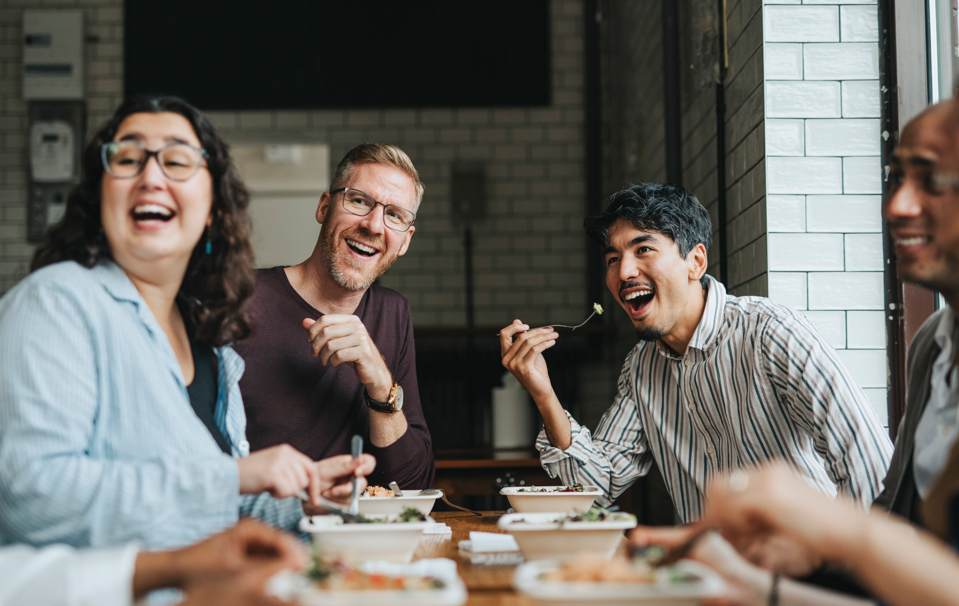 Medarbetare äter middag och diskuterar förmåner och uppskattning på arbetet